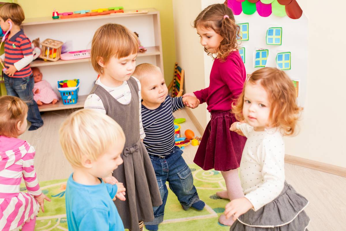Group of little children dancing with joy holding hands
